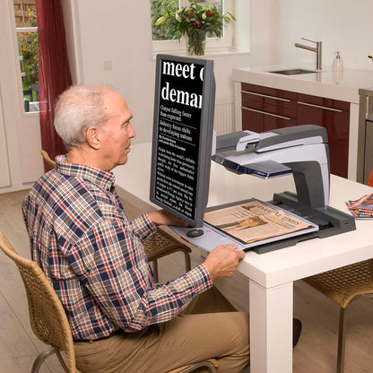 Older man viewing magnified newspaper on ClearView+