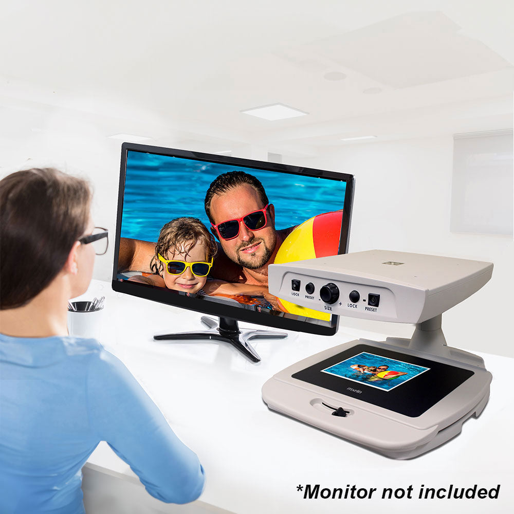 Young woman viewing beach family vacation photos with Merlin basic attached to monitor, monitor not included